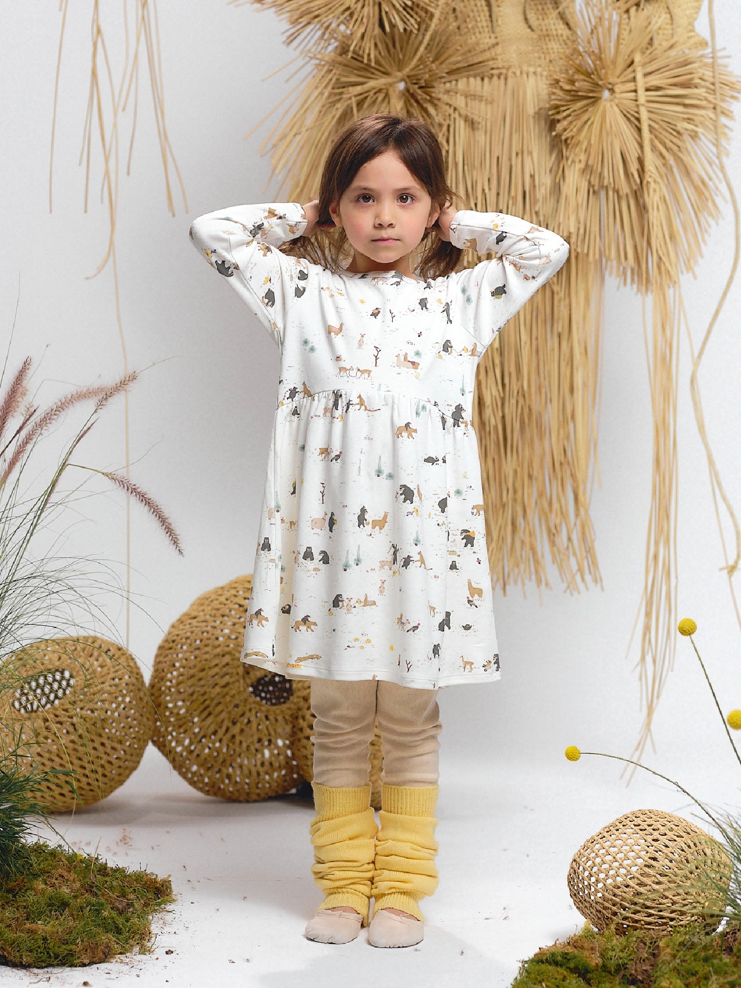 White dress with the Animal of the Story print — featuring spectacled bear, alpaca, puma, and other Andean animals.