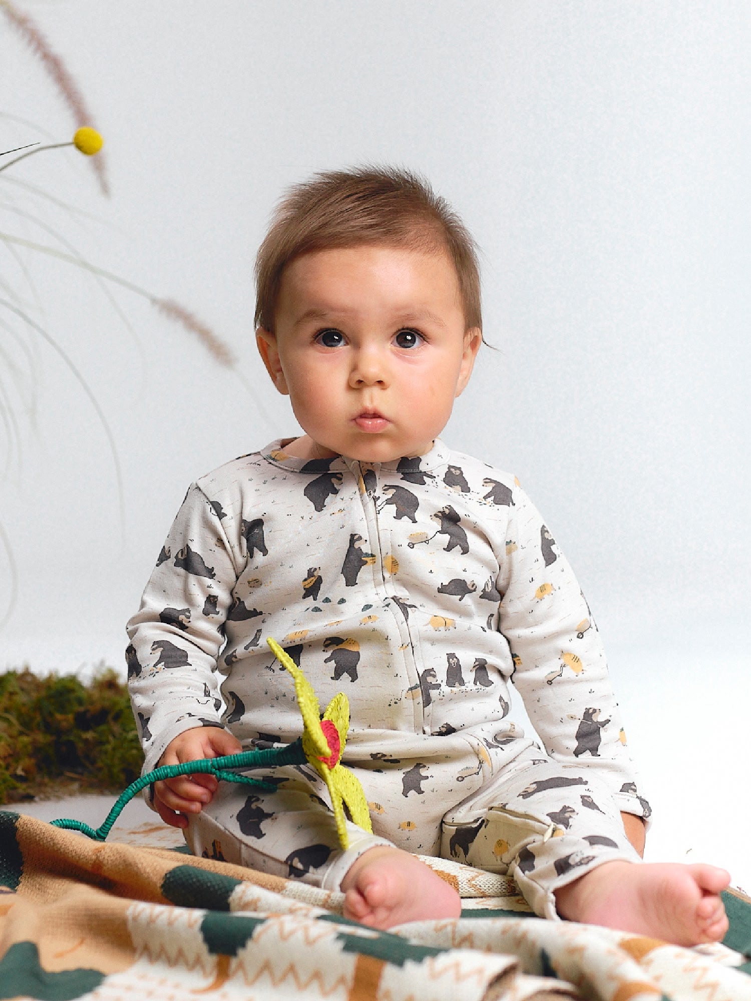 Cream zippered jumpsuit with spectacled bear print.