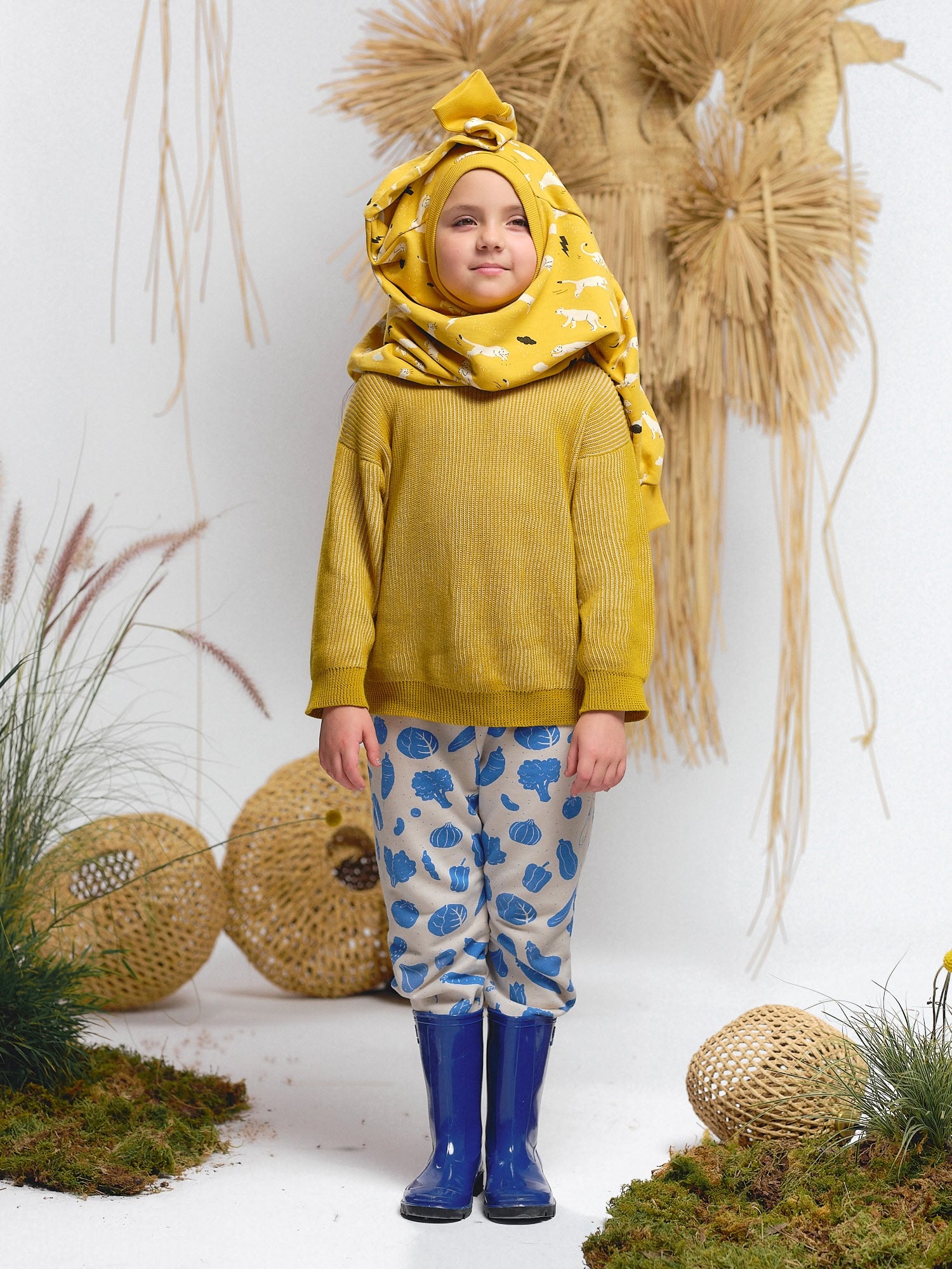 Mustard knit sweater paired with veggie print pants and a thunder puma sweatshirt styled as a head wrap.